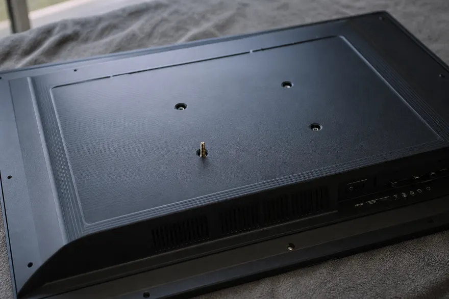 Rear panel of a flat-screen TV with four threaded VESA mounting holes